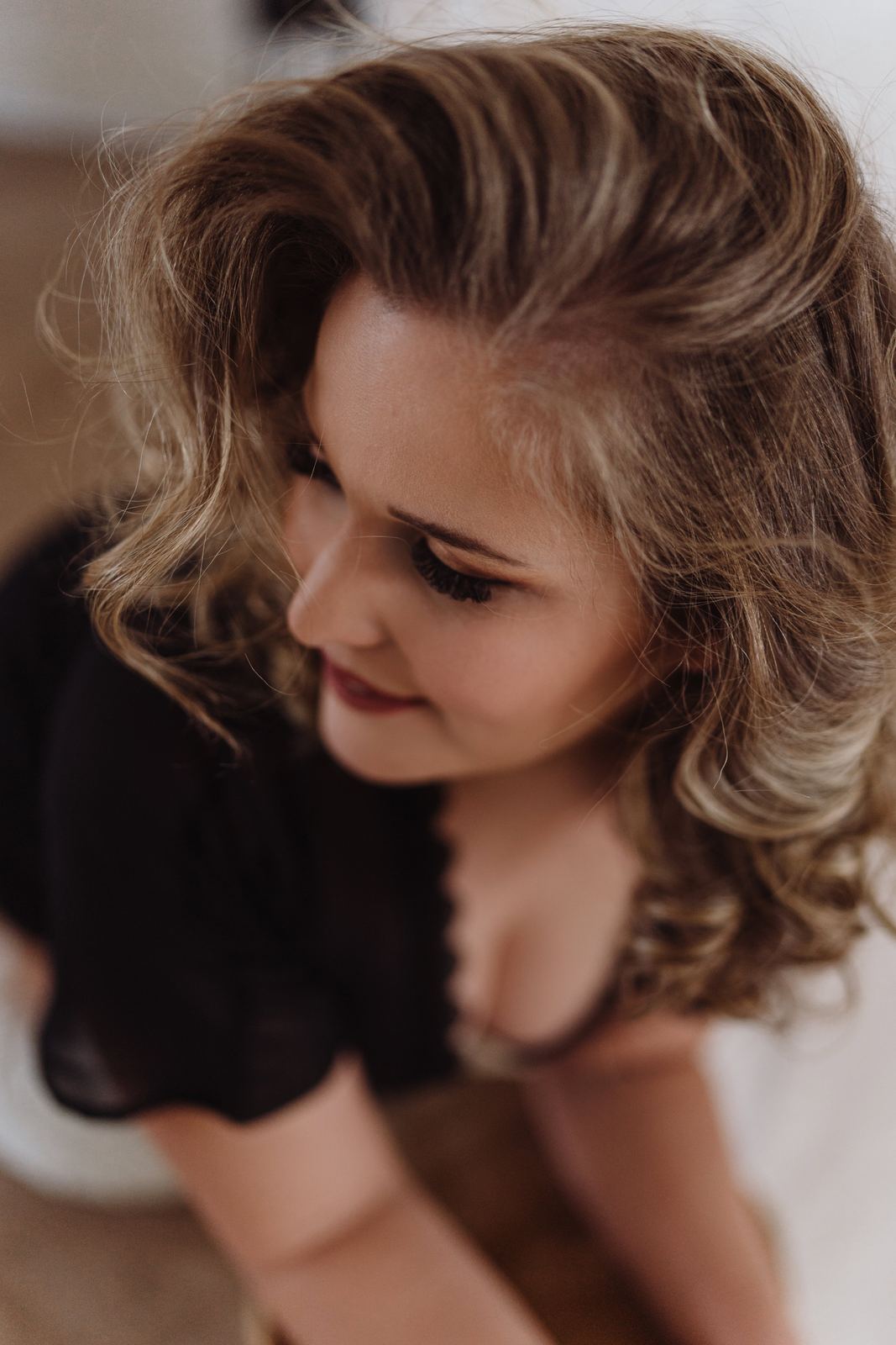 Vanessa blickt lächelnd nach unten, die Haare fallen ins Gesicht