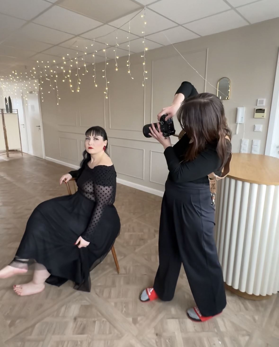Nina fotografiert eine Kundin im hellen Studio